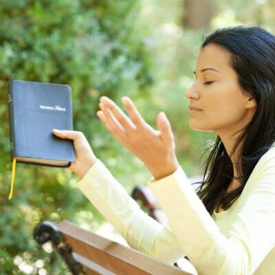 Mulher orando com a biblia